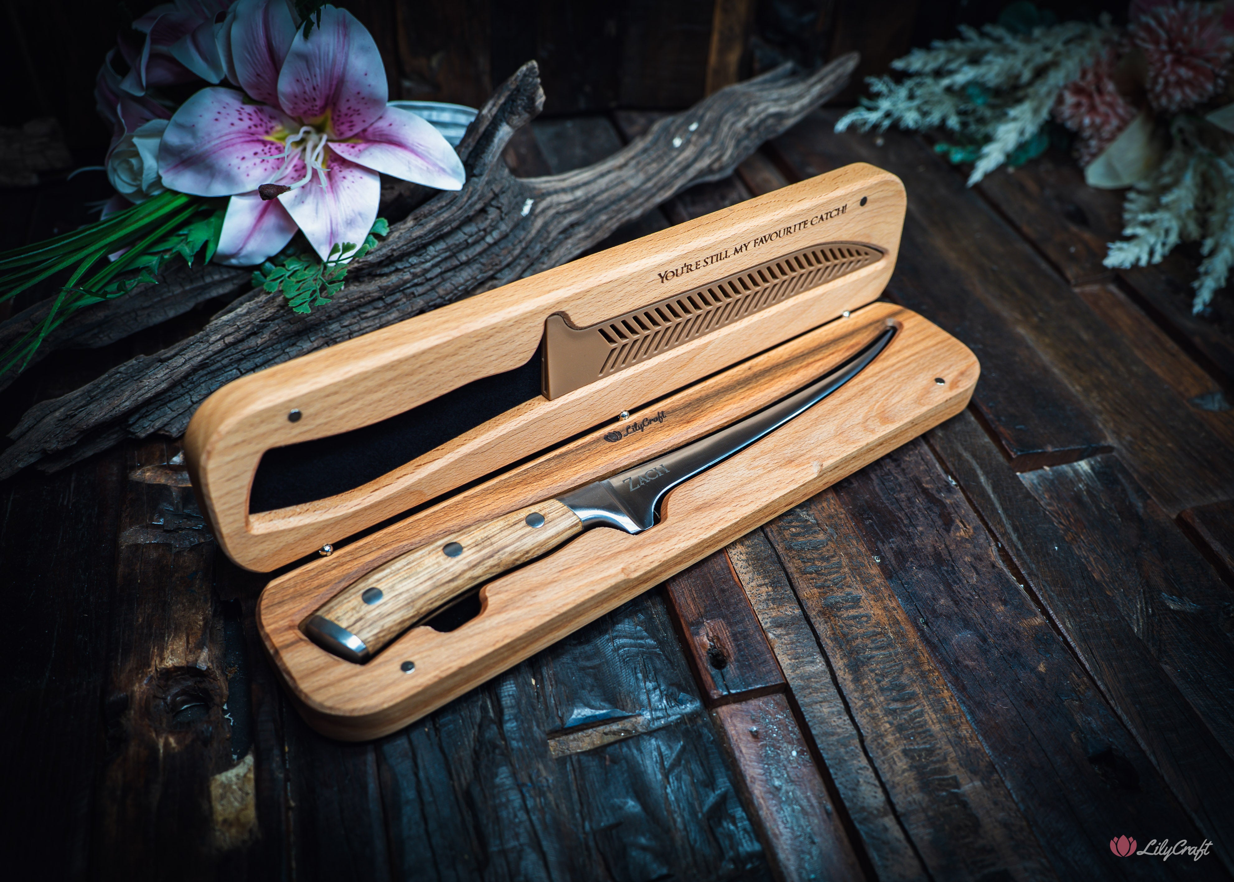 Flexible fish filleting knife resting in open custom carved beech wood gift box