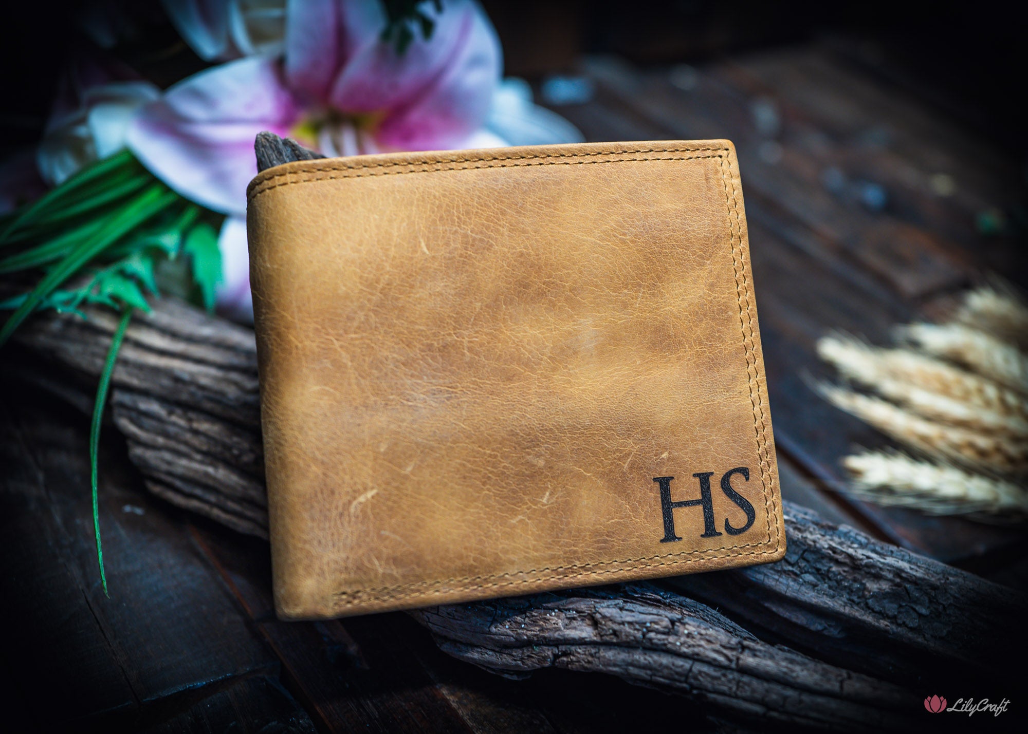 Personalised tan cowhide wallet open to show cash compartments and engraved flap.