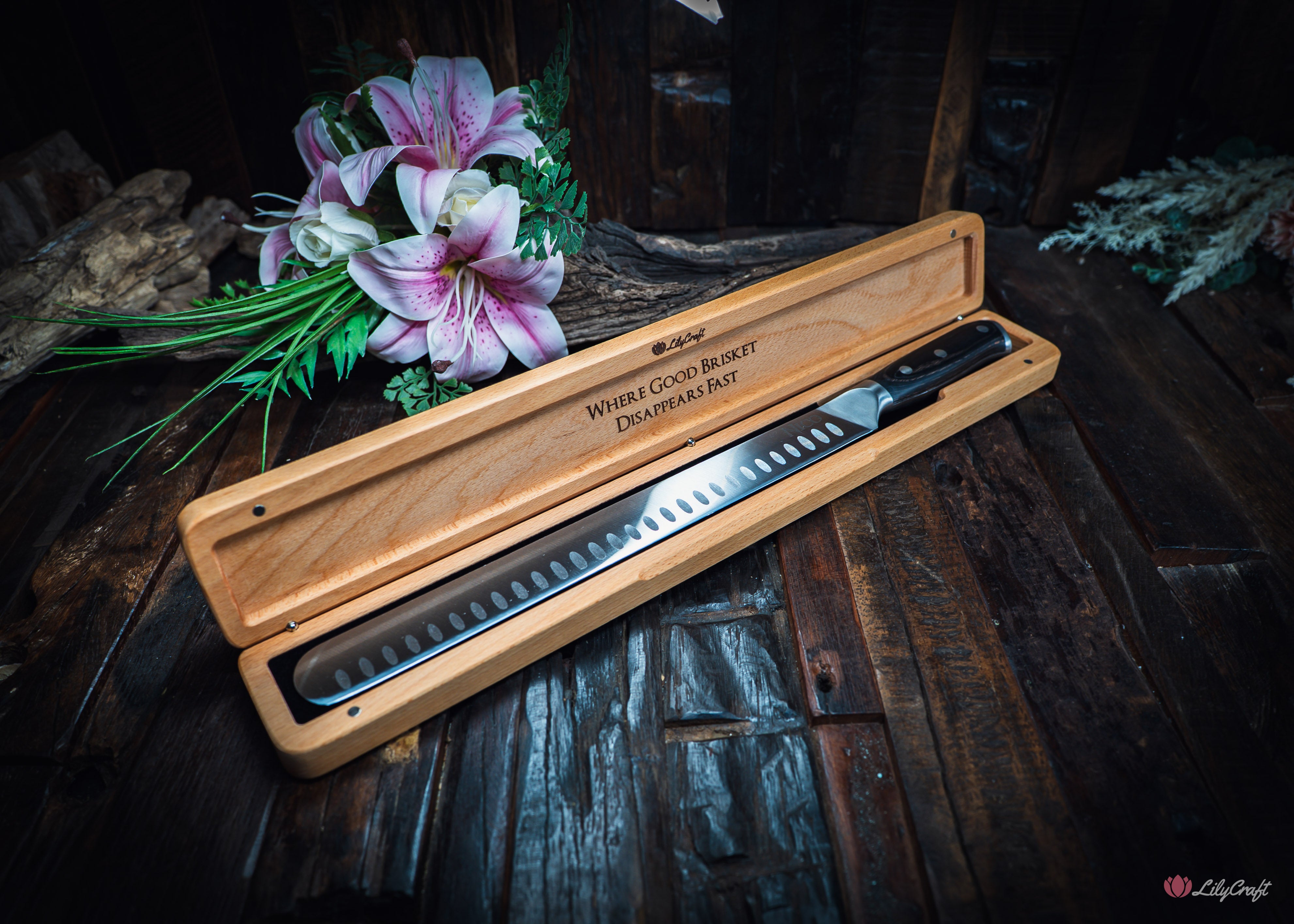 Long slicing knife cutting thin slices of smoked beef brisket on cutting board