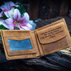 Vintage tan cowhide men’s leather wallet opened to show engraving on the coin pocket flap.