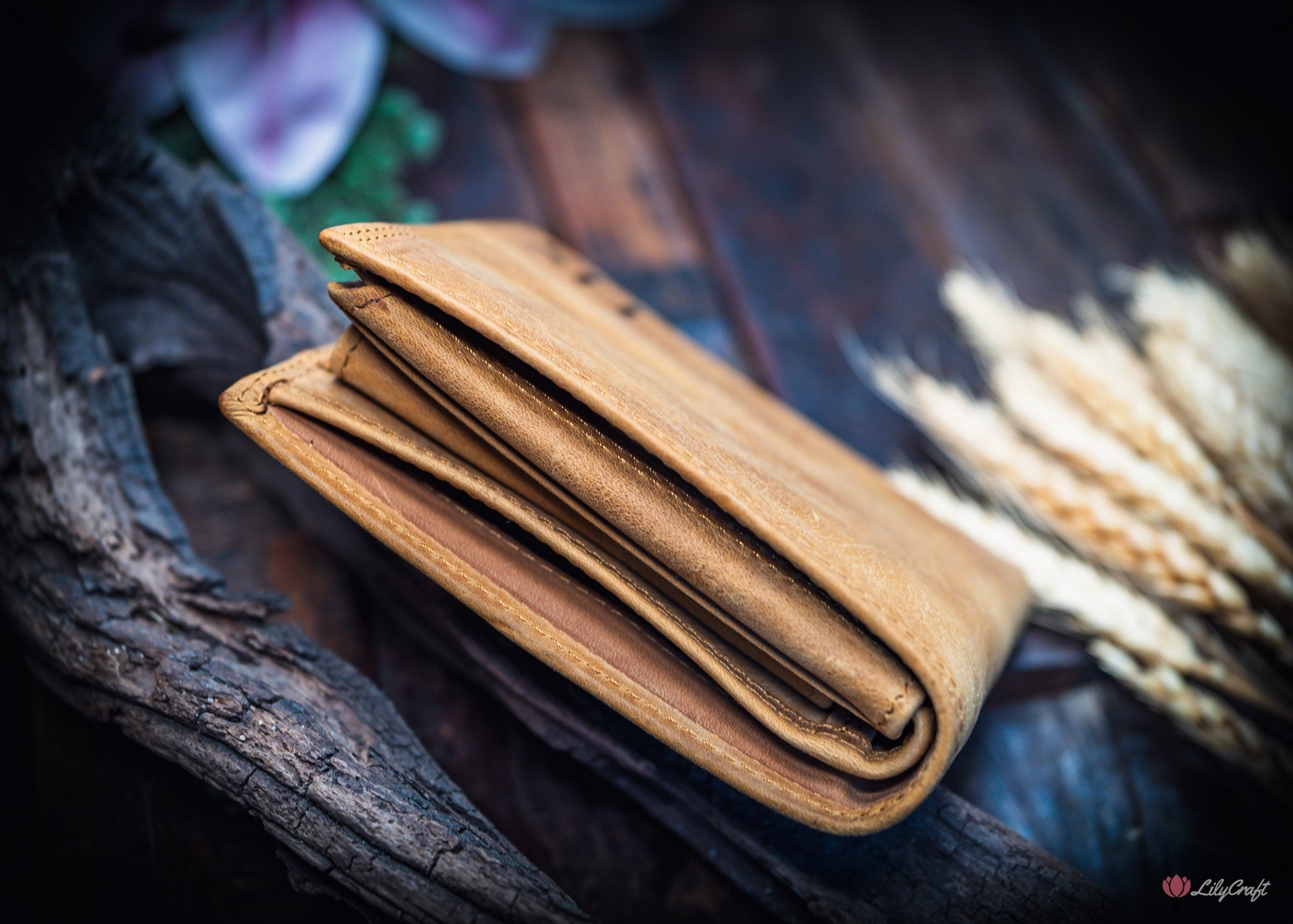 Tan leather wallet with coin pocket and engraved message displayed in natural light.